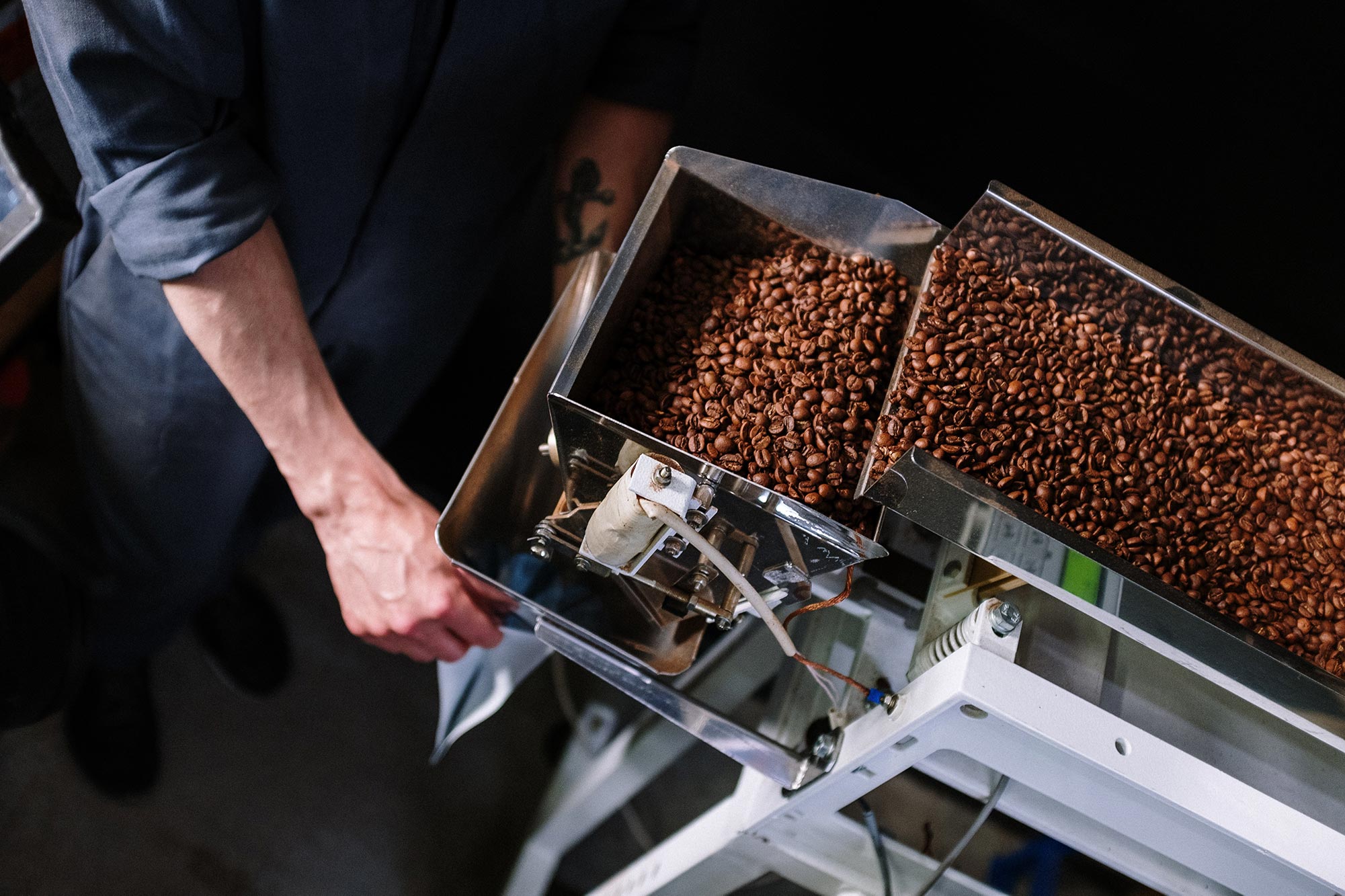 Coffee beans being dispensed into a bag.